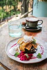 Stack of vegan pancakes, coffee and glass of water