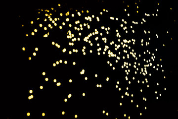 Unfocused gold sequins on a black background. Material for overlay and decoration of photos