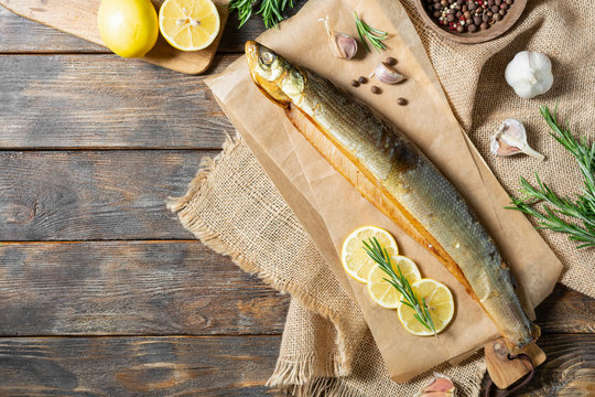 Fish omul cold smoked on a wooden table. Rustic style