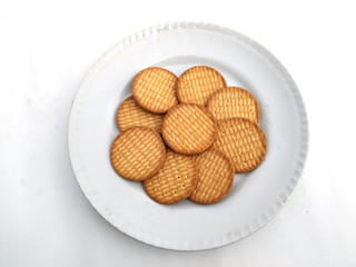 fresh healthy wheat biscuits put in a plate isolated on white background