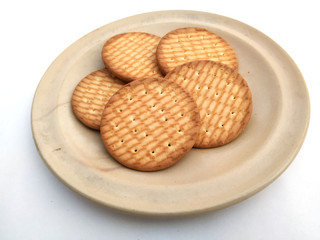 fresh healthy wheat biscuits put in a plate isolated on white background