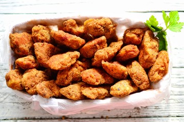 Chicken nuggets with a crispy crust. Delicious chicken meat on a wooden background. Fried meat, breast. 