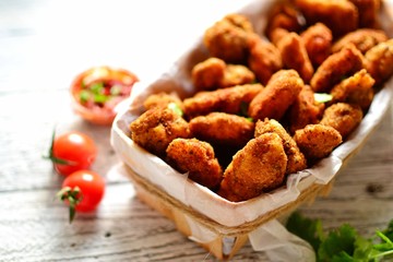 Chicken nuggets with a crispy crust. Delicious chicken meat on a wooden background. Fried meat, breast. 