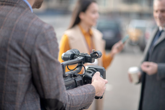 Viedo operator fixing his videocamera before recording a video