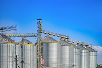 Agricultural Silos ,Industrial silos Storage and drying of grains with Blue Sky and White Clouds © prapann