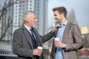Young businessman and his mature mentor having a conversation