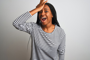 Young african american woman wearing striped t-shirt standing over isolated white background...