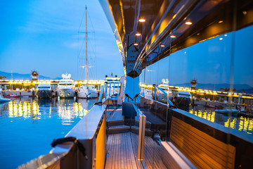 Beautiful illuminated Monacor port reflecting in the mirror walls of a luxury yacht