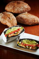 Black bread sandwich with baguette on background 