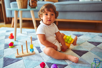 Beautiful toddler child girl playing with toys on the carpet