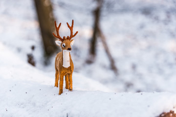 Toy Deer Doll in a Snowy Winter Forest