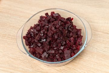 boiled сhopped beets-vegetables for salad in a transparent plate on the table