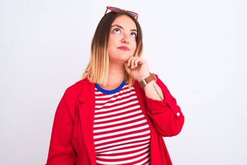 Young beautiful woman wearing striped t-shirt and jacket over isolated white background with hand on chin thinking about question, pensive expression. Smiling with thoughtful face. Doubt concept.