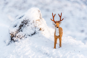 Toy Deer Doll in a Snowy Winter Forest