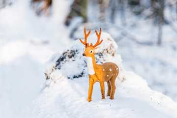 Toy Deer Doll in a Snowy Winter Forest
