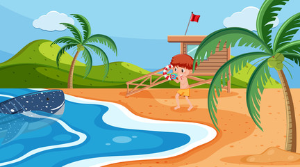 Beach scene with boy taking picture of whale