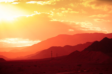 Mountain nature landscape. Desert in the early morning. Negev Desert. View of the valley with the silhouette of a mountain range in the background. The nature of Israel. The view from the car