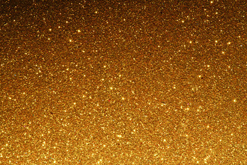 gold Sparkling Lights Festive background with texture. Abstract Christmas twinkled bright bokeh defocused and Falling stars. Winter Card or invitation	