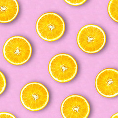 Fototapeta na wymiar Seamless pattern of oranges. Pastel pink background. Juicy orange in a cut. Citrus fruit.