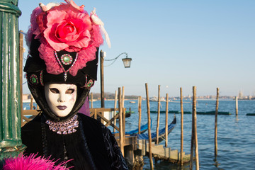 Obraz na płótnie Canvas Female mask at the Venice carnival wearing a black and pink dress