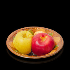 Two baked apples in a ceramic bowl on a black background