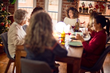 Beautiful group of women smiling happy and confident. Eating roasted turkey celebrating christmas at home