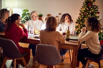 Beautiful group of women smiling happy and confident. Eating roasted turkey celebrating christmas at home