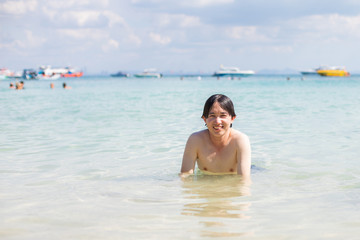 Happy handsome Asian man in the sea