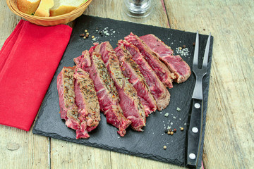 rib of beef grilled in slice on a wooden table