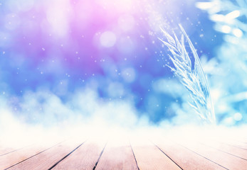 Winter abstract background. Empty wooden snow countertop. Snow covered grass in the background