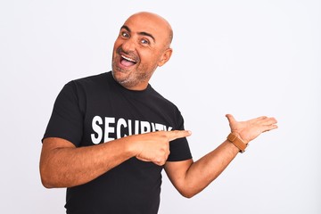 Middle age safeguard man wearing security uniform standing over isolated white background amazed and smiling to the camera while presenting with hand and pointing with finger.