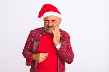 Middle age man wearing Christmas Santa hat standing over isolated white background touching mouth with hand with painful expression because of toothache or dental illness on teeth. Dentist concept.