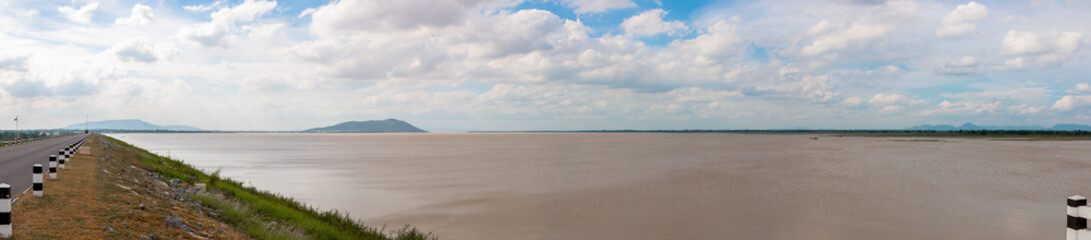 Landscape of Pasak Jolasid Dam with mountain and sky on summer showing little water capacity cause by hot weather.