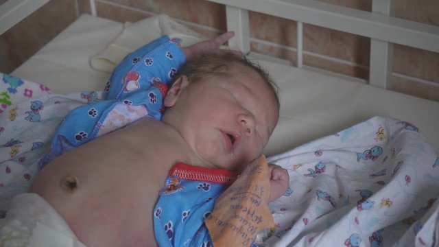 Little caucasian boy beautiful baby infant lies in the hospital before discharge. Maternity hospital, close-up