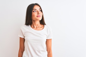 Young beautiful woman wearing casual t-shirt standing over isolated white background smiling looking to the side and staring away thinking.