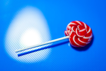 red candy on blue background with reflex