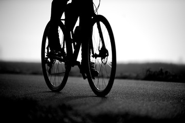 Fototapeta na wymiar Black and white photo of the road bike and legs of a man.