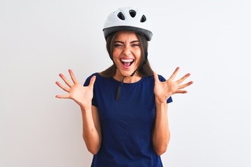Young beautiful cyclist woman wearing security bike helmet over isolated white background celebrating crazy and amazed for success with arms raised and open eyes screaming excited. Winner concept