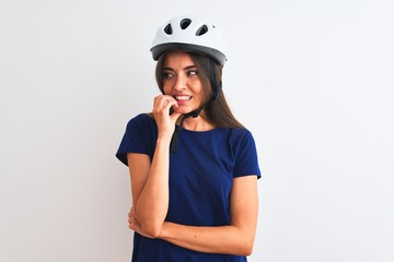 Young beautiful cyclist woman wearing security bike helmet over isolated white background looking stressed and nervous with hands on mouth biting nails. Anxiety problem.