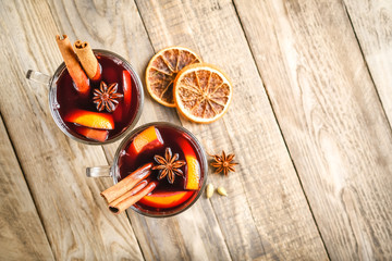 Mulled wine in glasses with apples, orange, cinnamon and star anise. Hot Christmas drink on a...