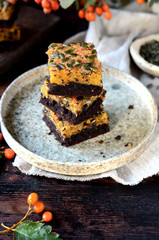 Chocolate pumpkin brownie on a plate on a dark wooden background, still life
