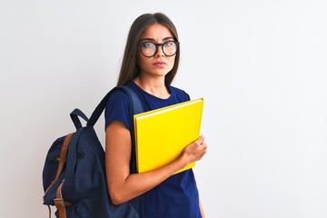 Young student woman wearing backpack glasses holding book over isolated white background with a confident expression on smart face thinking serious