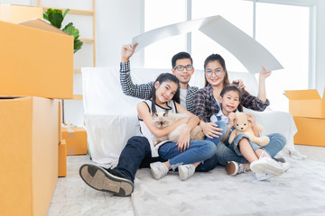 asian family relax and sitting on floor near sofa, they moving to new resident, they feeling happy...
