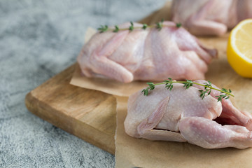 Raw uncooked quail. raw meat quails ready for cooking on a cutting board with copy space