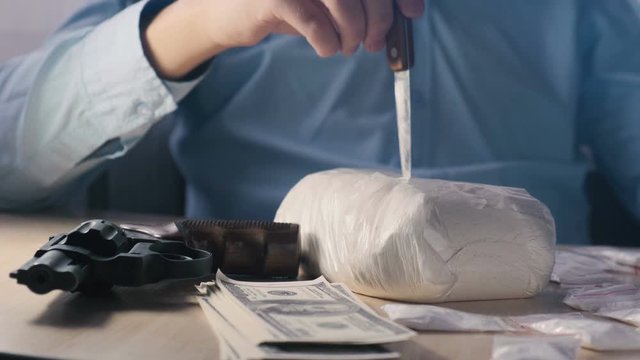 Drug dealer punching knife with heroin pack. The concept of drug trafficking and the black drug market