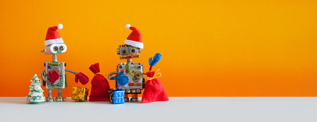 Toy robots Santas with a bunch of New Year's holiday gifts and a Christmas tree. Kind children's...