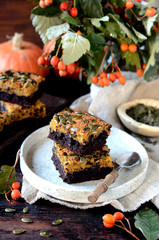 Chocolate pumpkin brownie on a plate on a dark wooden background, still life