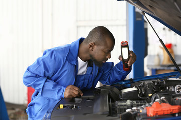 African-American mechanic working in car service center
