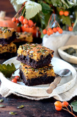 Chocolate pumpkin brownie on a plate on a dark wooden background, still life