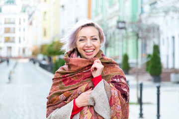 Portrait of a young woman in a scarf on the background of the city.